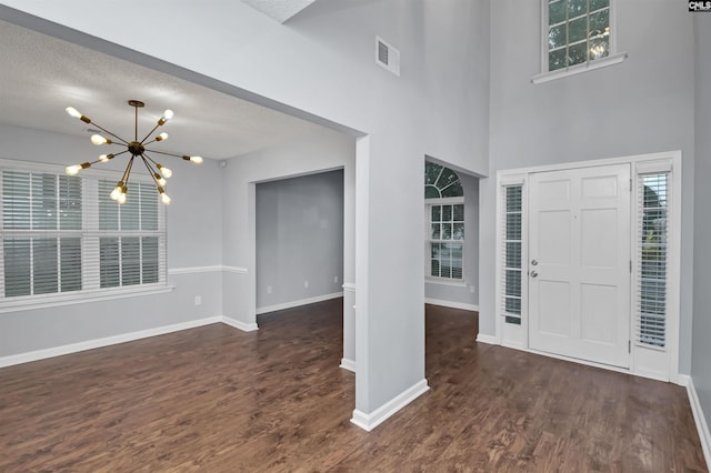 140 Otago Way W, Columbia, SC 29170 - foyer entrance featuring a chandelier, dark wood-style floors, baseboards, a textured ceiling, and a high ceiling