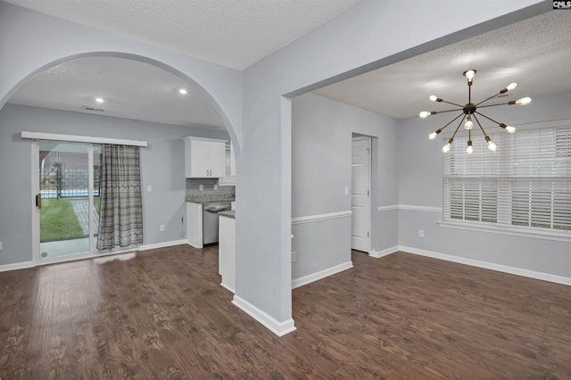 140 Otago Way W, Columbia, SC 29170 - unfurnished living room featuring arched walkways, a textured ceiling, dark wood finished floors, a chandelier, and baseboards