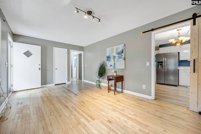 1818 Stratford Rd, Cayce, SC 29033 - unfurnished room featuring a barn door, light wood-style floors, a chandelier, and baseboards