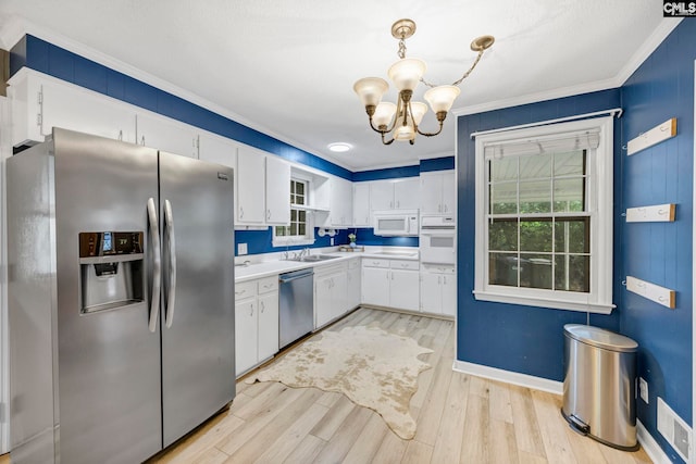 1818 Stratford Rd, Cayce, SC 29033 - kitchen with appliances with stainless steel finishes, crown molding, a chandelier, white cabinetry, and light countertops