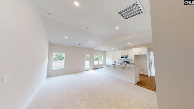 225 Trotter Ln, Orangeburg, SC 29118 - unfurnished living room featuring light colored carpet, recessed lighting, baseboards, vaulted ceiling, and a sink