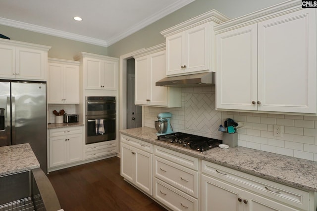 138 Long Cove Dr, Blythewood, SC 29016 - kitchen with appliances with stainless steel finishes, under cabinet range hood, backsplash, white cabinetry, and crown molding