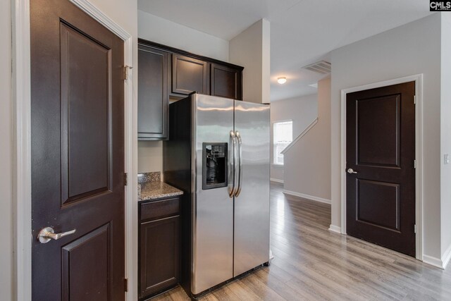 301 Chestnut Oak Ct, West Columbia, SC 29169 - kitchen with stainless steel fridge, dark brown cabinetry, light wood finished floors, stone countertops, and baseboards