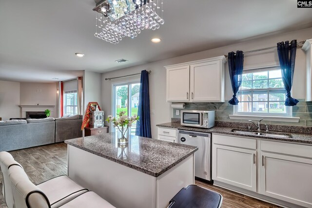2121 Connor Way, Newberry, SC 29108 - kitchen with appliances with stainless steel finishes, wood finished floors, a kitchen island, a sink, and white cabinetry