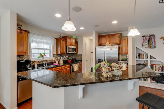 1123 Triple Crown Ct, Elgin, SC 29045 - kitchen with stainless steel appliances, brown cabinetry, a breakfast bar, decorative backsplash, and recessed lighting