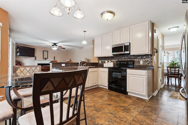 209 Walden Place Cir, Elgin, SC 29045 - kitchen featuring stainless steel microwave, black electric range oven, a ceiling fan, decorative backsplash, and white cabinets