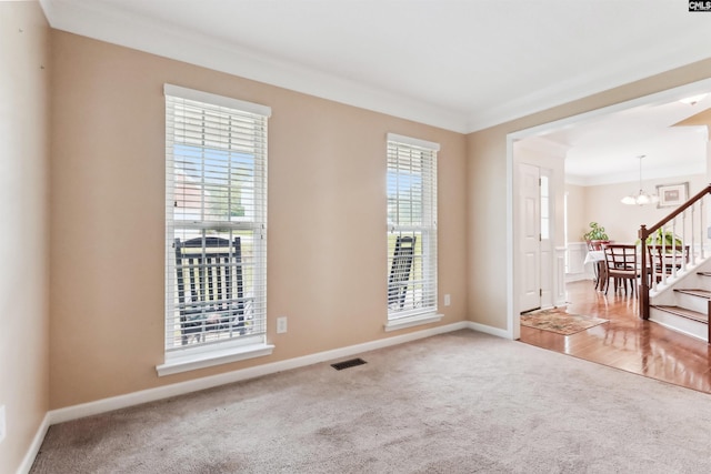 209 Walden Place Cir, Elgin, SC 29045 - spare room featuring carpet floors, a chandelier, ornamental molding, baseboards, and stairs