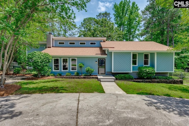 2308 Exton Shore Dr, Columbia, SC 29209 - mid-century inspired home with a front lawn, roof with shingles, and a chimney