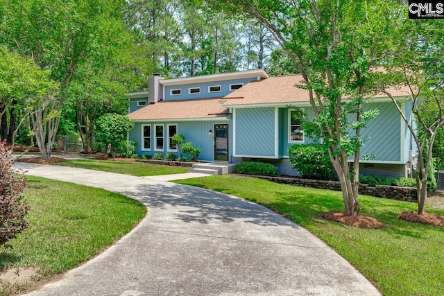 2308 Exton Shore Dr, Columbia, SC 29209 - mid-century modern home featuring a front lawn, a chimney, a shingled roof, brick siding, and driveway
