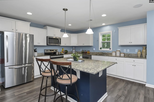 53 Findlay Cir, Elgin, SC 29045 - kitchen featuring stainless steel appliances, a sink, dark wood finished floors, white cabinetry, and a center island
