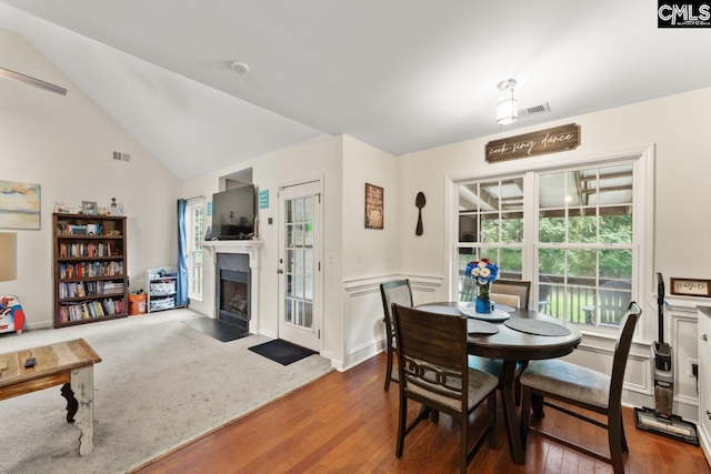 612 Williams Cir, West Columbia, SC 29172 - dining space featuring a fireplace with flush hearth, hardwood / wood-style flooring, a wainscoted wall, and vaulted ceiling
