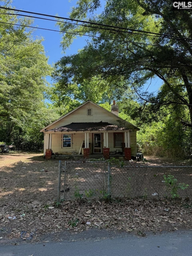 453 Fagan Rd, Winnsboro, SC 29180 - bungalow featuring a fenced front yard, covered porch, and a chimney