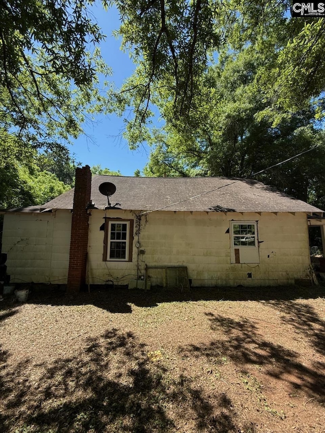 453 Fagan Rd, Winnsboro, SC 29180 - view of side of property featuring concrete block siding, a shingled roof, and a chimney