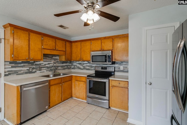 11 Parkhaven Ct, Columbia, SC 29209 - kitchen featuring appliances with stainless steel finishes, a sink, brown cabinetry, backsplash, and light countertops