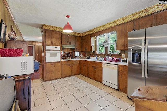 2015 Valley View Rd, West Columbia, SC 29172 - kitchen with white appliances, light countertops, under cabinet range hood, brown cabinets, and light tile patterned floors