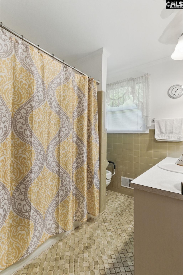 2015 Valley View Rd, West Columbia, SC 29172 - full bathroom featuring tile walls, toilet, tile patterned floors, vanity, and a wainscoted wall