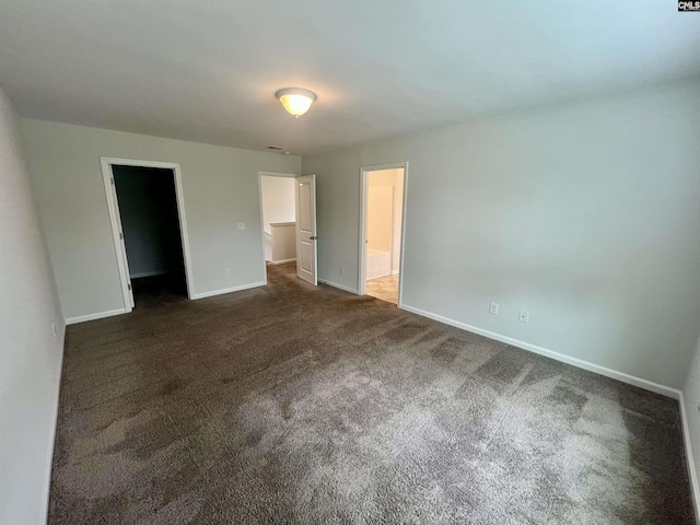 1069 Roscoe Rd, Lexington, SC 29073 - unfurnished bedroom featuring a walk in closet, dark carpet, baseboards, and a closet
