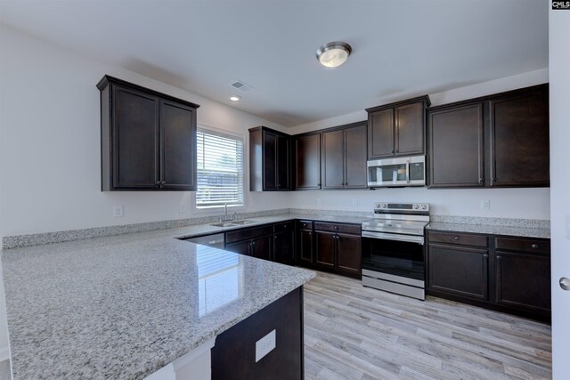 812 Poplar Bend Rd, Columbia, SC 29229 - kitchen with appliances with stainless steel finishes, a sink, a peninsula, dark brown cabinetry, and recessed lighting