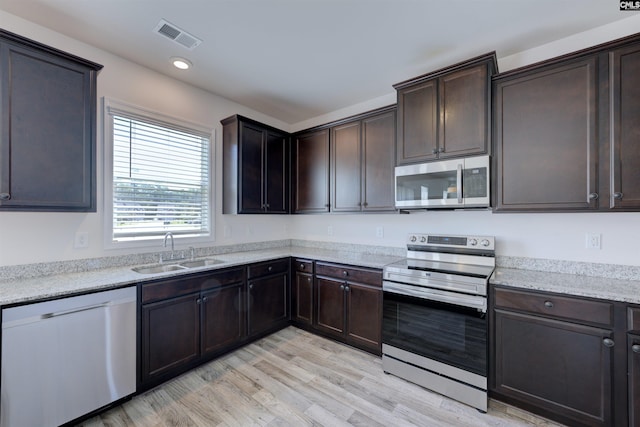 812 Poplar Bend Rd, Columbia, SC 29229 - kitchen featuring appliances with stainless steel finishes, a sink, light wood finished floors, dark brown cabinetry, and recessed lighting