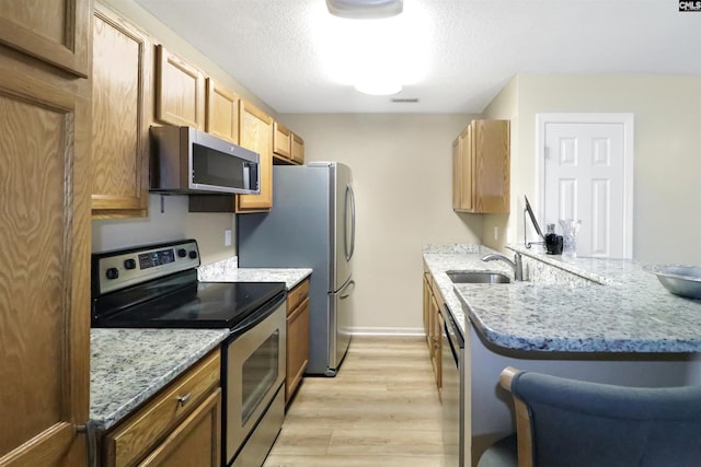 1306 Waverly Place Dr, Columbia, SC 29223 - kitchen with appliances with stainless steel finishes, a sink, light wood-type flooring, light stone counters, and baseboards
