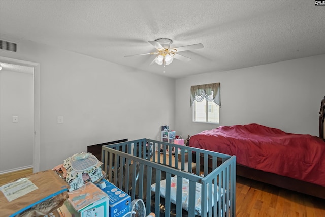 1208 Bush River Rd Unit G10, Columbia, SC 29210 - bedroom featuring wood finished floors, a textured ceiling, and a ceiling fan
