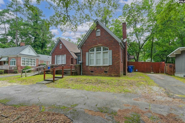 709 Sunset Dr, Columbia, SC 29203 - tudor home with brick siding, a chimney, a gate, and crawl space