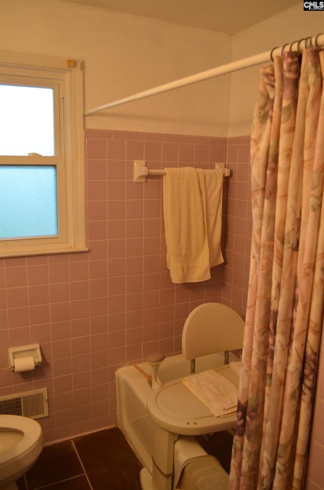 828 Seay Dr, West Columbia, SC 29170 - full bathroom with toilet, tile walls, a shower with curtain, tile patterned floors, and wainscoting