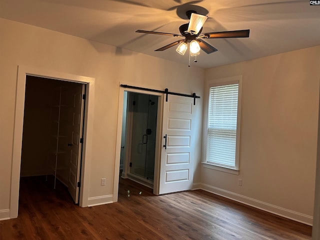 1781 Bookman Rd, Elgin, SC 29045 - unfurnished bedroom with dark wood-style floors, a barn door, and baseboards
