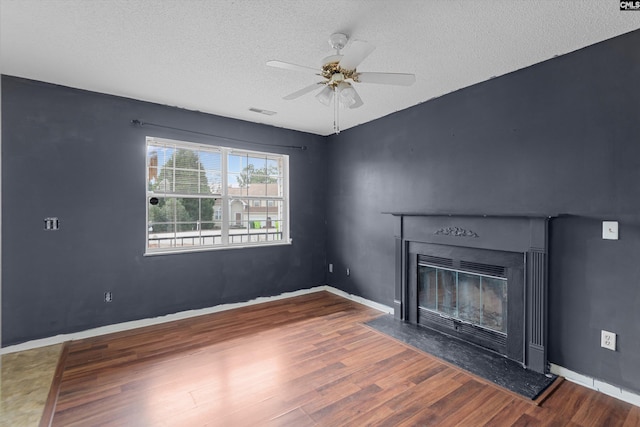 2 Berry Ridge Ct, Columbia, SC 29229 - unfurnished living room with wood finished floors, a textured ceiling, a glass covered fireplace, a ceiling fan, and baseboards