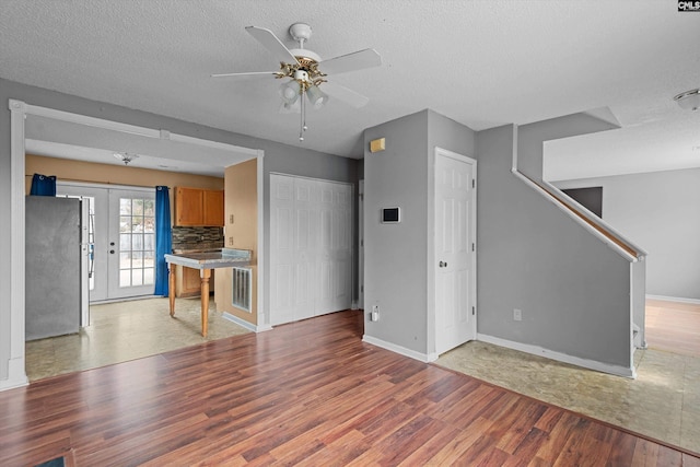 2 Berry Ridge Ct, Columbia, SC 29229 - unfurnished living room with light wood finished floors, ceiling fan, baseboards, stairs, and a textured ceiling