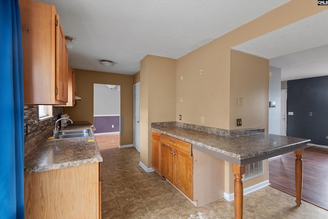 2 Berry Ridge Ct, Columbia, SC 29229 - kitchen with a sink, baseboards, decorative backsplash, brown cabinetry, and a textured ceiling