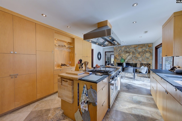 208 Gibbs Rd, Elgin, SC 29045 - kitchen featuring wall chimney exhaust hood, recessed lighting, a kitchen island, light stone finish flooring, and a fireplace