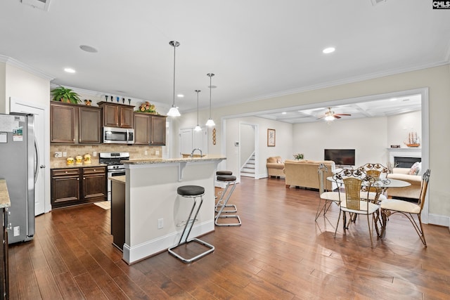 122 Lost Lure Ln, Chapin, SC 29036 - kitchen featuring appliances with stainless steel finishes, ceiling fan, backsplash, dark wood-style flooring, and a breakfast bar area
