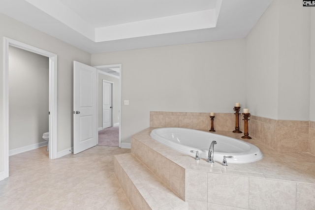 122 Lost Lure Ln, Chapin, SC 29036 - bathroom featuring a garden tub, toilet, a raised ceiling, baseboards, and tile patterned flooring