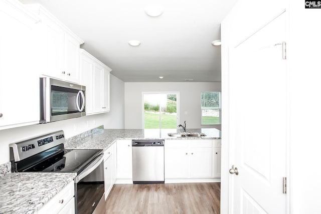307 Sundew Rd, Elgin, SC 29045 - kitchen featuring appliances with stainless steel finishes, a sink, light wood-type flooring, and white cabinetry