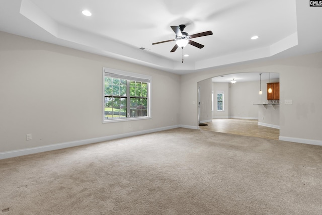 309 Tanners Mill Ct, Chapin, SC 29036 - unfurnished living room featuring a tray ceiling, arched walkways, light carpet, ceiling fan, and recessed lighting