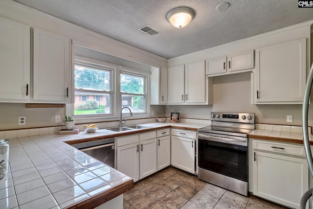 1820 Elm Abode Ter, Columbia, SC 29210 - kitchen with stainless steel appliances, a sink, tile counters, white cabinetry, and a textured ceiling