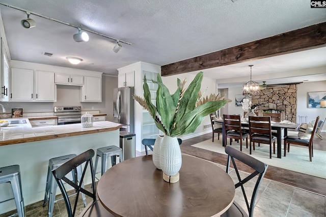1820 Elm Abode Ter, Columbia, SC 29210 - dining space with beamed ceiling, a textured ceiling, track lighting, and a chandelier