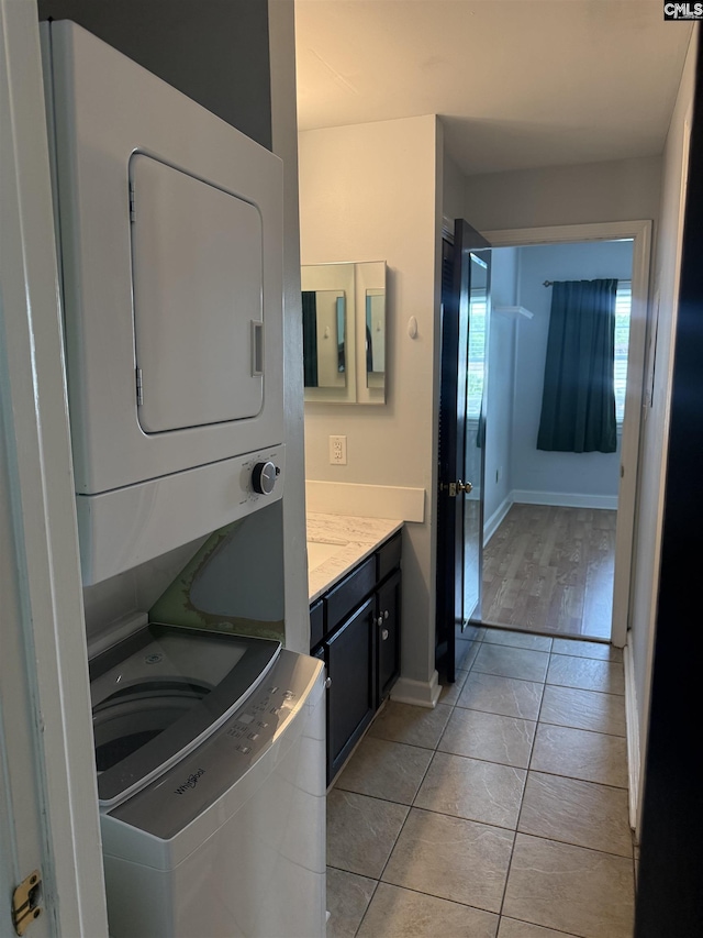 2002 Greene St Unit 113, Columbia, SC 29205 - laundry area featuring stacked washer / drying machine, baseboards, and light tile patterned floors