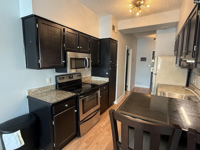2002 Greene St Unit 113, Columbia, SC 29205 - kitchen with stainless steel appliances, a sink, light wood finished floors, and a textured ceiling