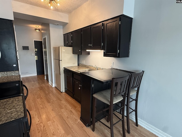 2002 Greene St Unit 113, Columbia, SC 29205 - kitchen featuring a sink, black dishwasher, dark cabinets, light wood-style floors, and freestanding refrigerator