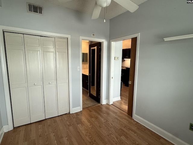 2002 Greene St Unit 113, Columbia, SC 29205 - unfurnished bedroom featuring a closet, baseboards, wood finished floors, ensuite bath, and a ceiling fan