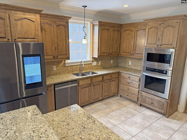 601 Cartgate Cir, Blythewood, SC 29016 - kitchen with stainless steel appliances, a sink, brown cabinets, light stone countertops, and crown molding