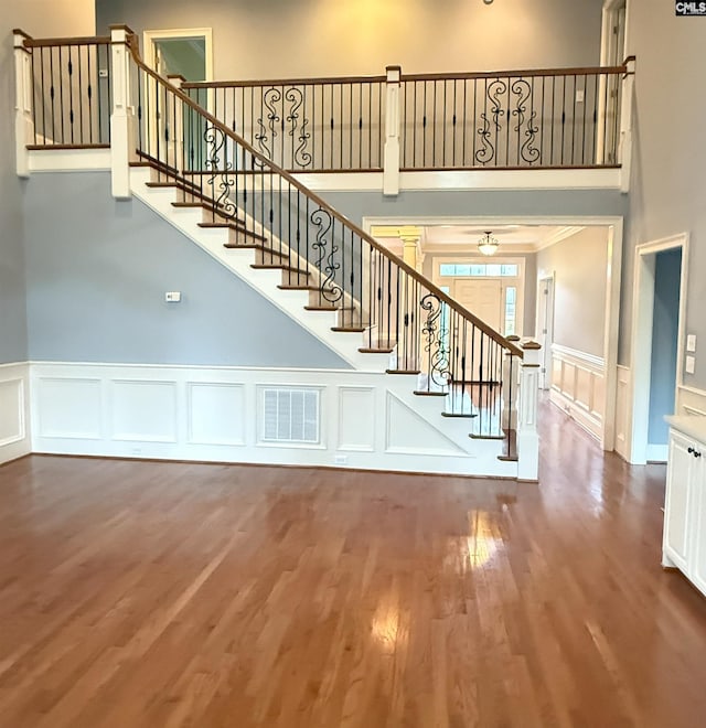 601 Cartgate Cir, Blythewood, SC 29016 - staircase with a towering ceiling, a decorative wall, wood finished floors, and wainscoting