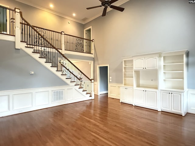 601 Cartgate Cir, Blythewood, SC 29016 - unfurnished living room with ornamental molding, a towering ceiling, a ceiling fan, stairs, and wood finished floors