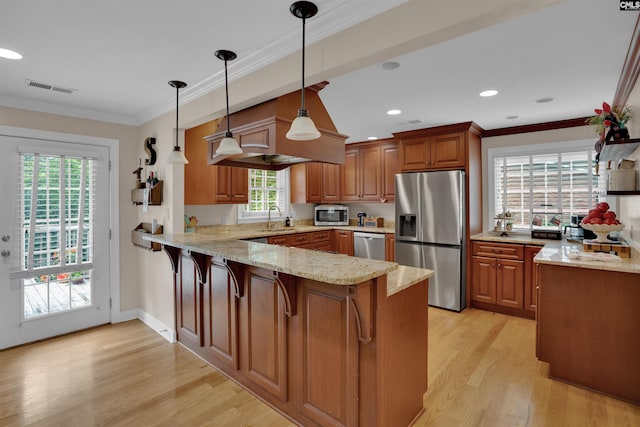 531 Sulgrave Dr, Columbia, SC 29210 - kitchen featuring stainless steel appliances, a peninsula, a sink, brown cabinets, and light stone counters