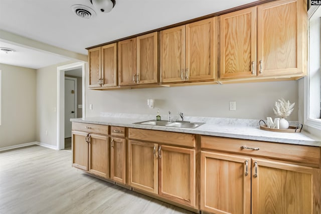 3201 Wilton Rd, West Columbia, SC 29170 - kitchen featuring a sink, light wood-type flooring, light stone counters, and baseboards