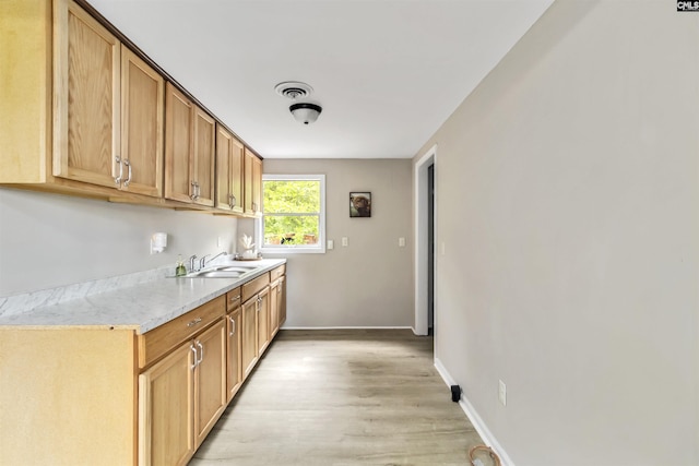 3201 Wilton Rd, West Columbia, SC 29170 - kitchen featuring a sink, light countertops, light wood-type flooring, and baseboards