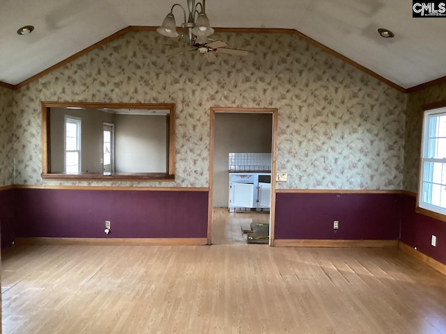 127 Dry Gulch Rd, Saluda, SC 29138 - unfurnished living room featuring vaulted ceiling, wallpapered walls, wood finished floors, a wainscoted wall, and ceiling fan