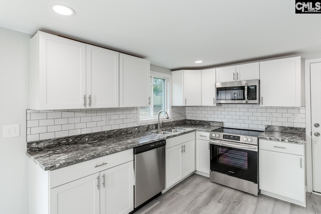 104 Big John Rd, Elgin, SC 29045 - kitchen with stainless steel appliances, white cabinets, a sink, dark stone countertops, and recessed lighting